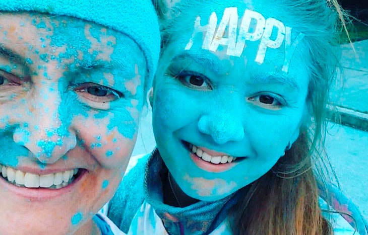 photo of two people covered in blue paint from participating in a Color Run