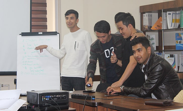 Male participants of the workshop presenting at a whiteboard.