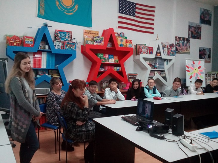 A group of students in a classroom watching a presentation.