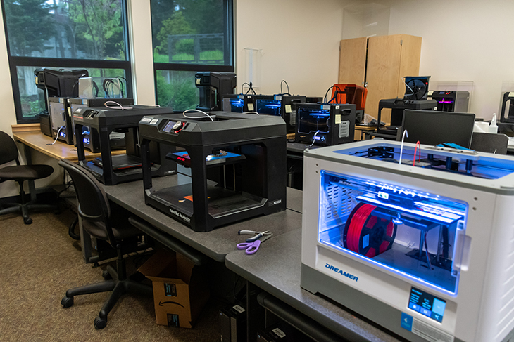A group of 3D printers in GRC's additive manufacturing lab print PPE