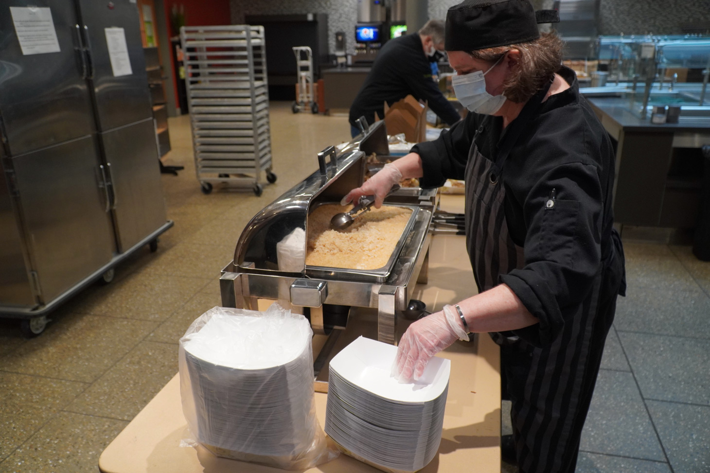 Tammy Sechler portions out rice for a jerk chicken bowl 