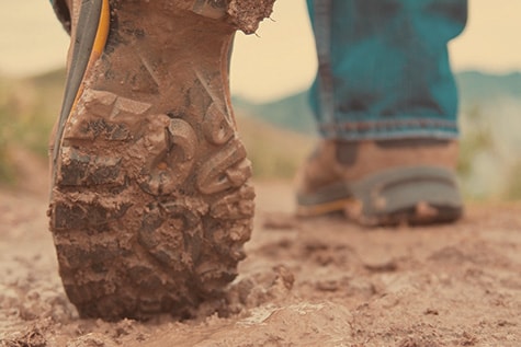 Work boots walking away in mud