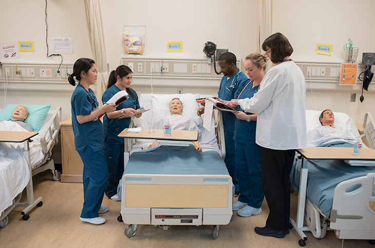 Green River College students work with their nursing instructor in the nursing SIM lab.