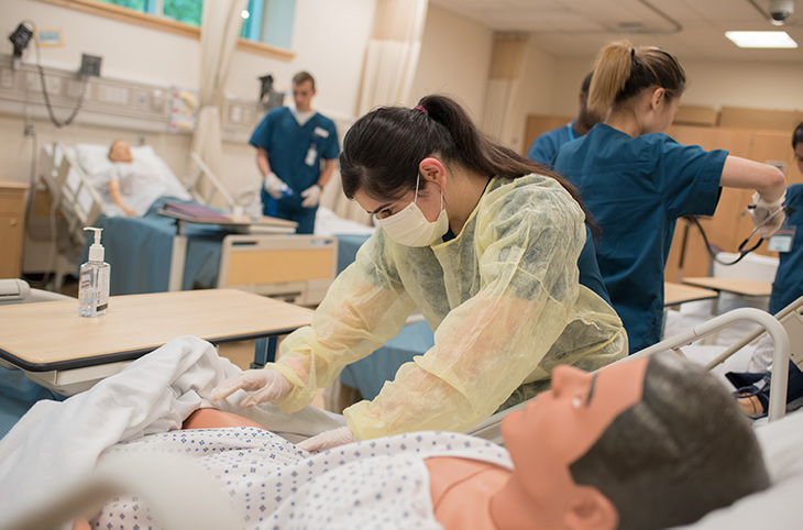 A Green River College nursing student practices on a medical dummy in the nursing SIM lab.