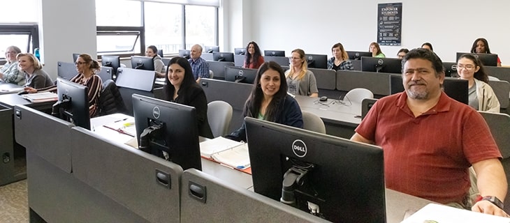 Adult Green River College students sitting in front of computers in a classroom.