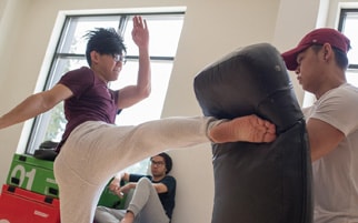 photo of an individual kicking a punching bag to promote Group Fitness Classes