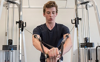 Photo of an individual using a weight machine to promote Open Gym
