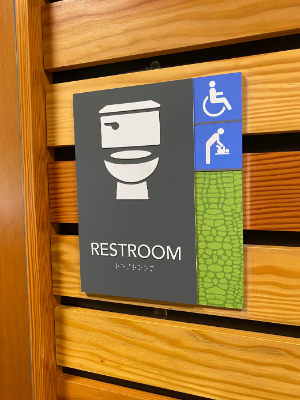 Image of new restroom sign with sybols for toliet, changing room, and accessibility